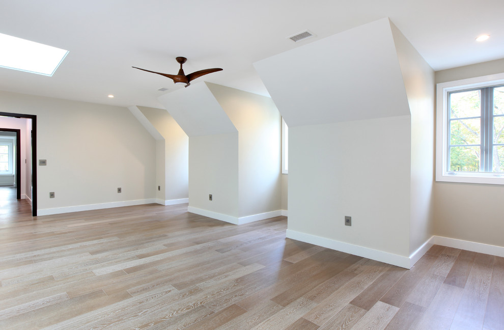 Geräumiges Modernes Gästezimmer ohne Kamin mit gelber Wandfarbe und braunem Holzboden in Sonstige