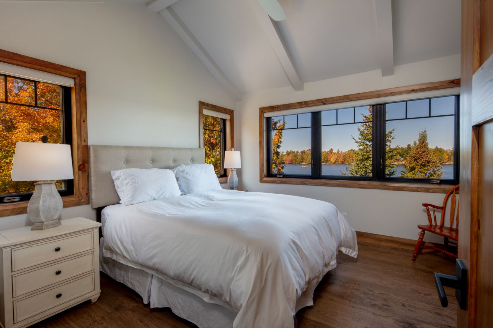 Rustikales Schlafzimmer mit weißer Wandfarbe, braunem Holzboden, braunem Boden, freigelegten Dachbalken und gewölbter Decke in Toronto