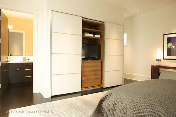 Imagen de habitación de invitados actual sin chimenea con paredes beige y suelo de madera oscura