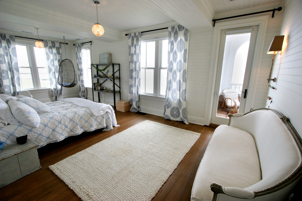 Modelo de dormitorio tradicional con paredes blancas y suelo de madera oscura