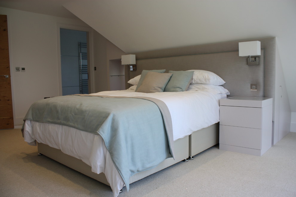 Medium sized contemporary master bedroom in Sussex with white walls and carpet.