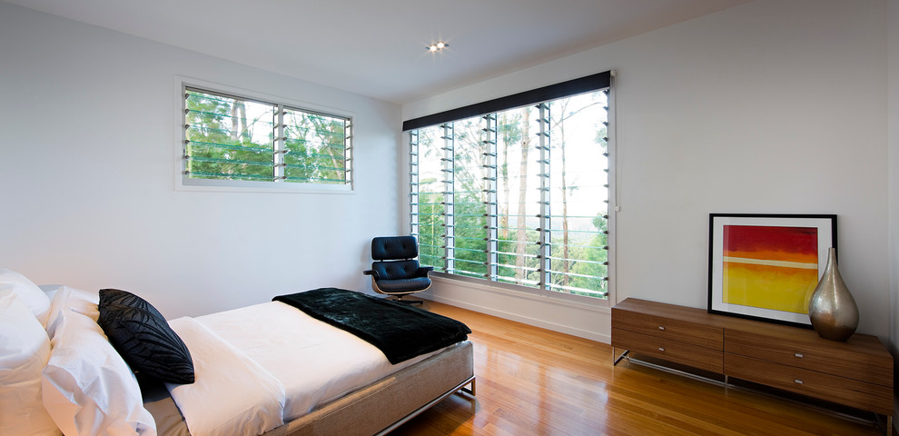 Foto di una camera da letto minimal con parquet chiaro, pareti bianche e nessun camino