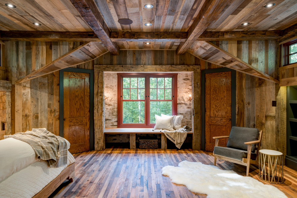 Bedroom - large rustic master medium tone wood floor bedroom idea in Other with brown walls and no fireplace