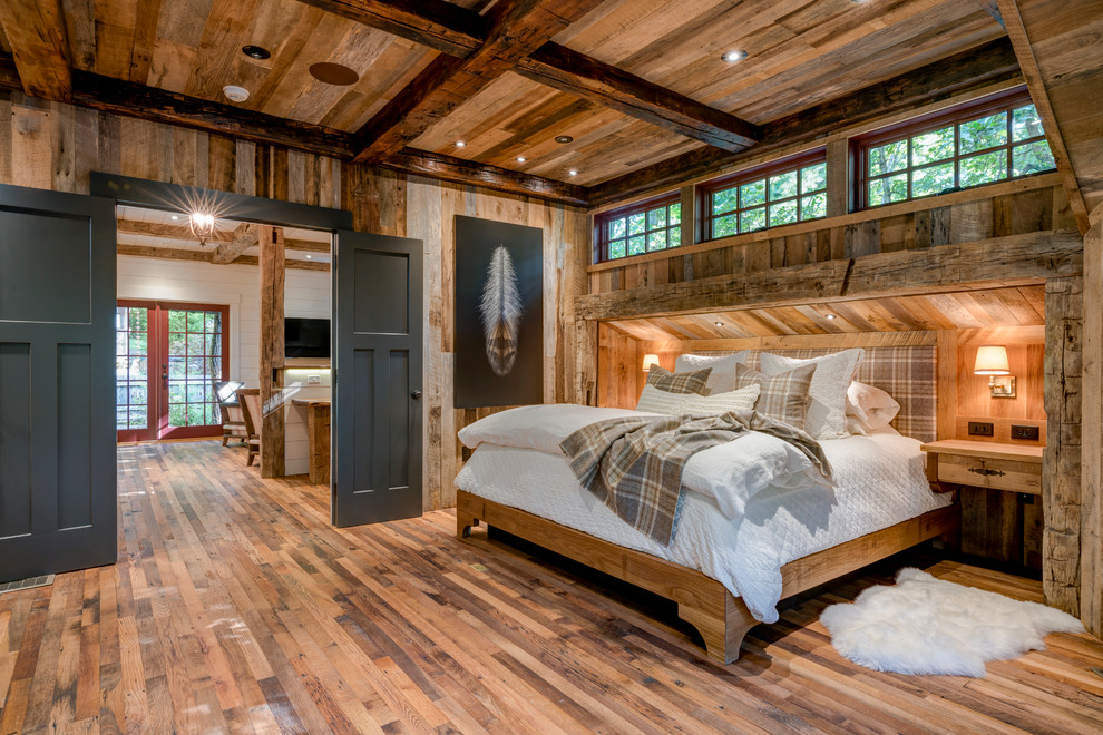 На фото: большая хозяйская спальня в стиле рустика с коричневыми стенами и паркетным полом среднего тона без камина