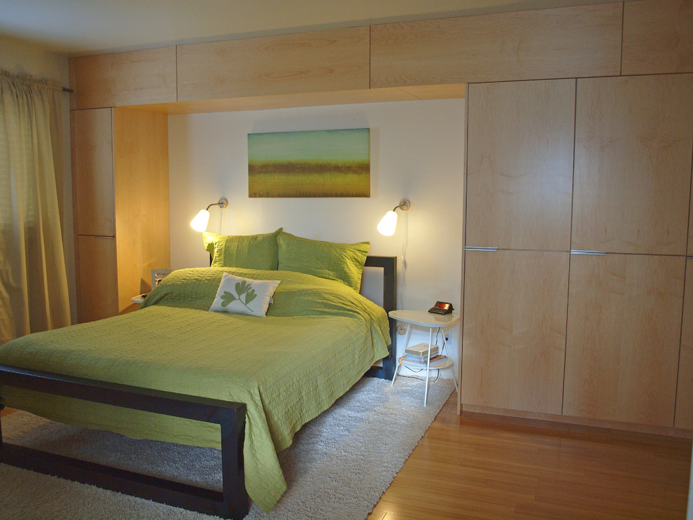Diseño de dormitorio principal actual de tamaño medio sin chimenea con paredes beige, suelo de bambú y suelo marrón