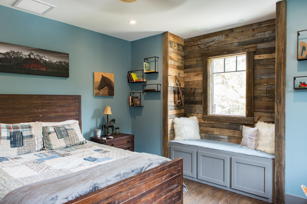 Modelo de dormitorio rústico de tamaño medio sin chimenea con paredes azules, suelo de madera oscura y suelo marrón