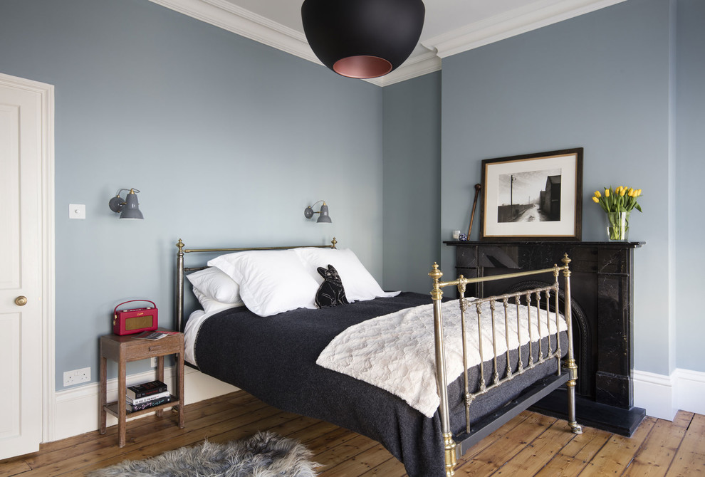 Diseño de dormitorio tradicional renovado con paredes grises, suelo de madera en tonos medios, todas las chimeneas y suelo marrón