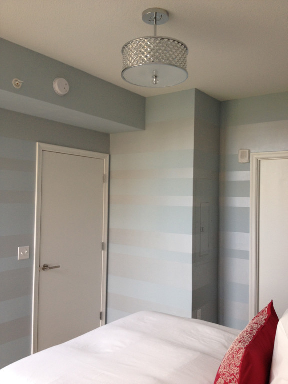 Large contemporary guest bedroom in DC Metro with blue walls, bamboo flooring and no fireplace.