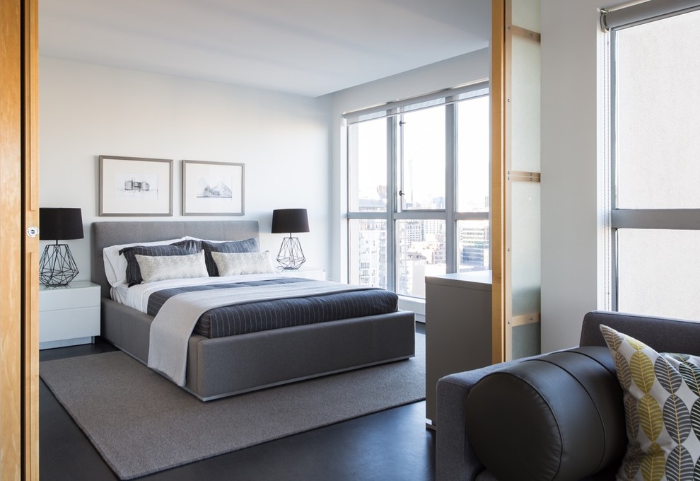 Example of a trendy master black floor bedroom design in Vancouver with white walls and no fireplace