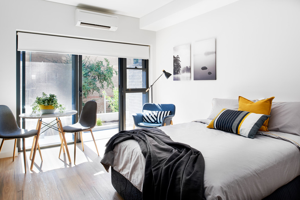 Immagine di una piccola camera da letto design con pareti bianche e pavimento in vinile