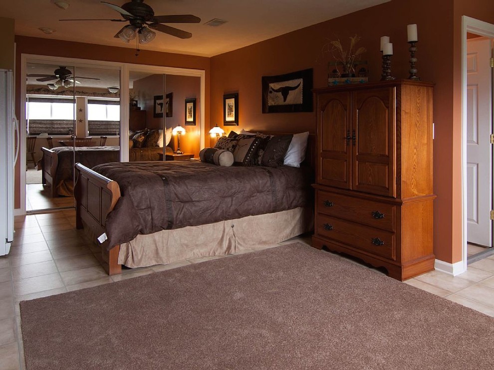 Imagen de habitación de invitados de estilo de casa de campo de tamaño medio con paredes marrones y suelo laminado