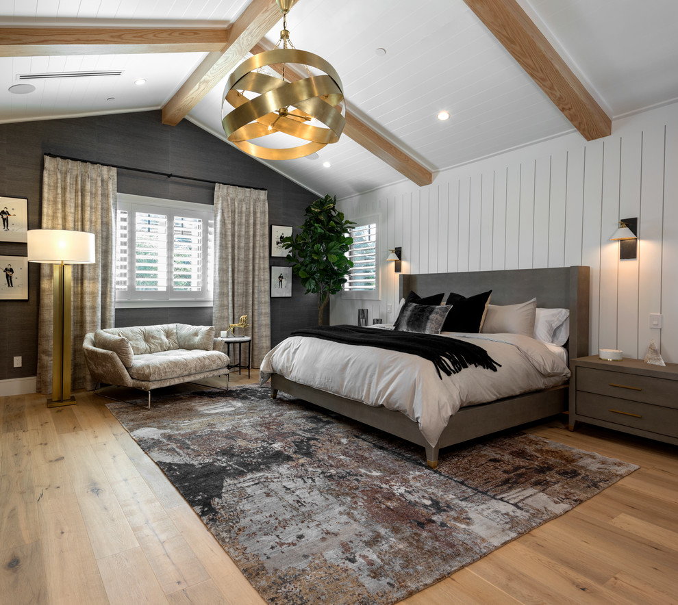 Traditional bedroom in Los Angeles with white walls, medium hardwood flooring and brown floors.