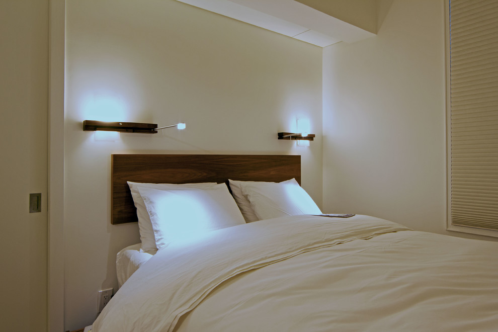 Modelo de dormitorio principal escandinavo pequeño con paredes blancas, suelo de madera pintada y suelo blanco