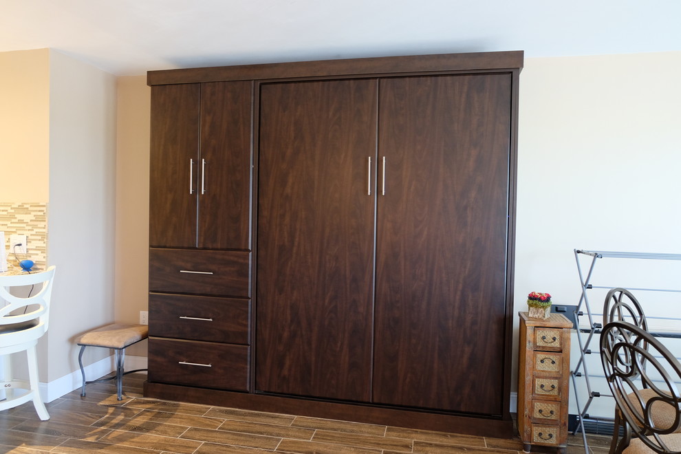 Idées déco pour une chambre mansardée ou avec mezzanine moderne avec un mur beige et un sol en bois brun.