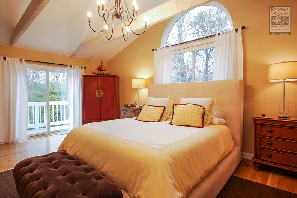 Inspiration för moderna sovrum, med gula väggar och mellanmörkt trägolv