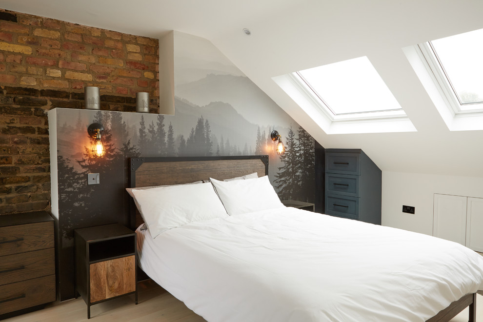 This is an example of an industrial guest bedroom in London with white walls, light hardwood flooring and beige floors.