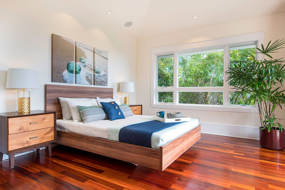 Maritimes Schlafzimmer mit weißer Wandfarbe und braunem Holzboden in Hawaii