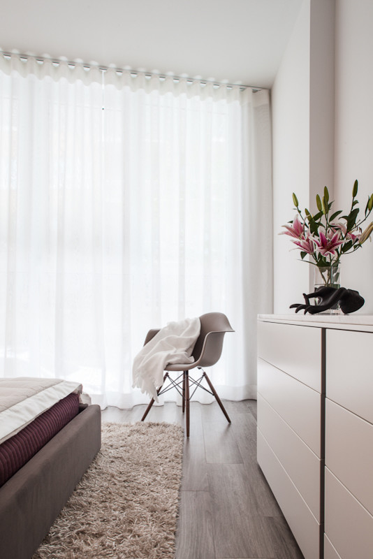 На фото: гостевая спальня среднего размера, (комната для гостей) в стиле модернизм с белыми стенами и полом из керамической плитки без камина