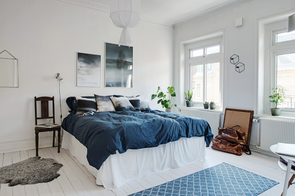 Источник вдохновения для домашнего уюта: большая хозяйская спальня в скандинавском стиле с белыми стенами и деревянным полом без камина