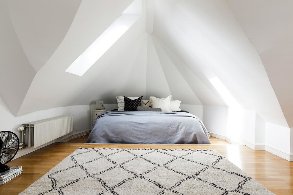 На фото: большая хозяйская спальня в скандинавском стиле с белыми стенами и паркетным полом среднего тона без камина с
