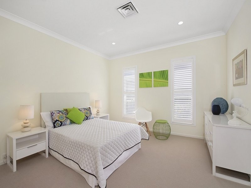 This is an example of a small modern bedroom in Sydney with carpet, no fireplace and beige floors.