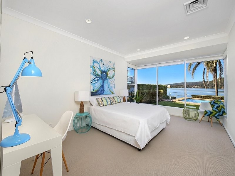 Example of a mid-sized beach style carpeted and beige floor bedroom design in Sydney with white walls and no fireplace