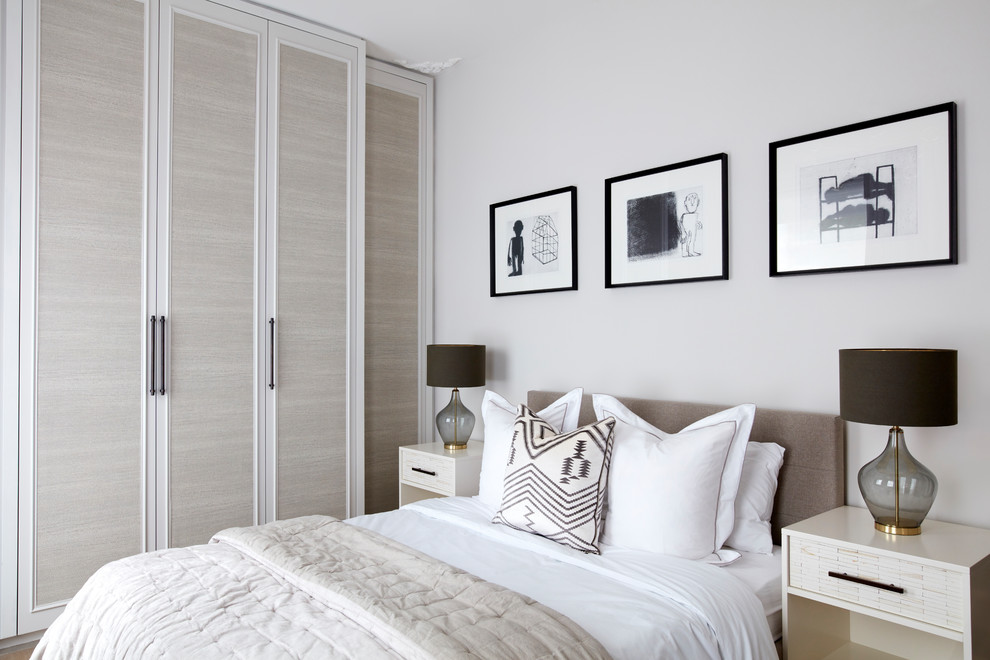 Design ideas for a medium sized traditional master and grey and silver bedroom in London with beige walls, laminate floors and beige floors.