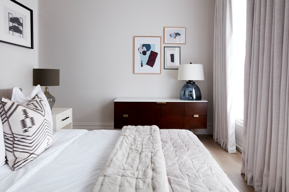 This is an example of a medium sized classic master bedroom in London with beige walls, laminate floors and beige floors.