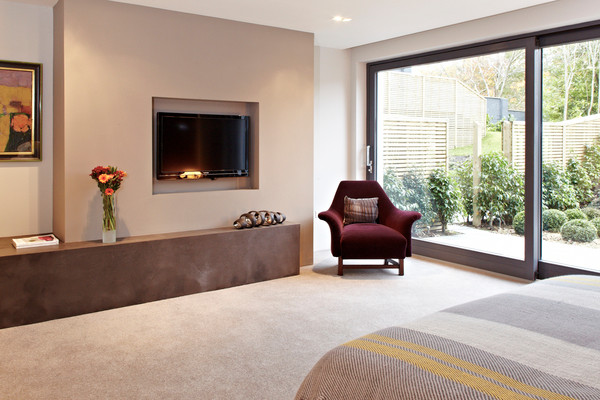 Large contemporary master bedroom in Belfast with carpet.
