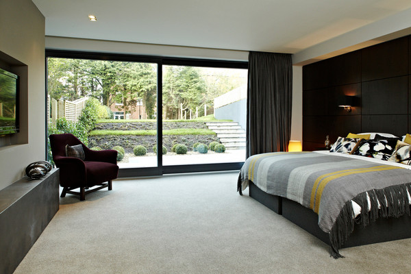 Photo of a large contemporary master bedroom in Belfast with carpet.