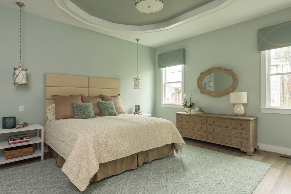 На фото: спальня в стиле неоклассика (современная классика) с зелеными стенами, паркетным полом среднего тона и коричневым полом