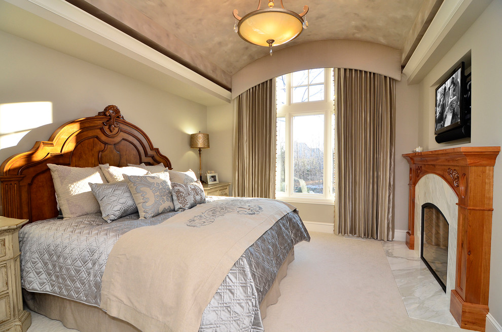 На фото: хозяйская спальня среднего размера в классическом стиле с бежевыми стенами, ковровым покрытием, стандартным камином и фасадом камина из камня с