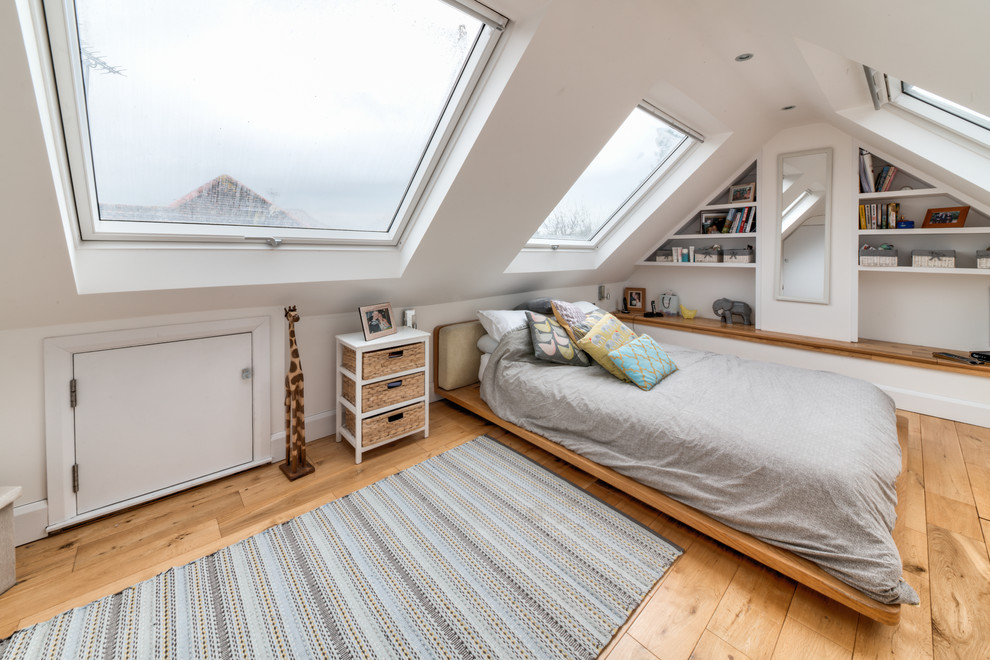 Example of a large trendy guest medium tone wood floor and brown floor bedroom design in London with white walls
