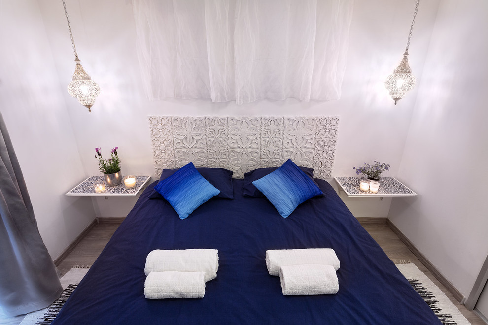 Foto di una piccola camera da letto etnica con pareti bianche, pavimento in laminato e pavimento beige