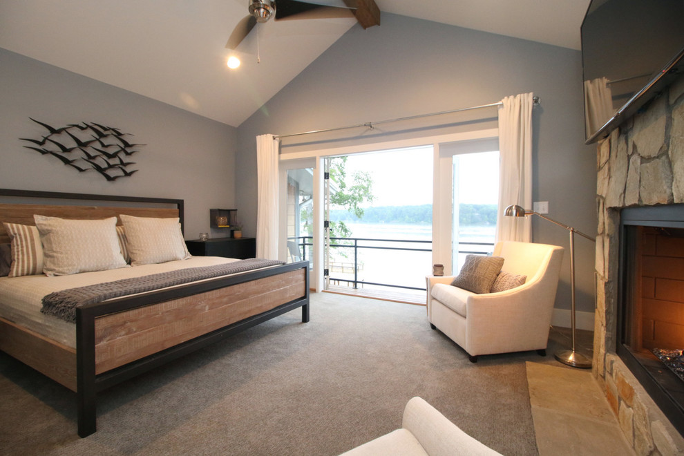 Rustikales Hauptschlafzimmer mit grauer Wandfarbe, Teppichboden, Kamin und Kaminumrandung aus Stein in Raleigh