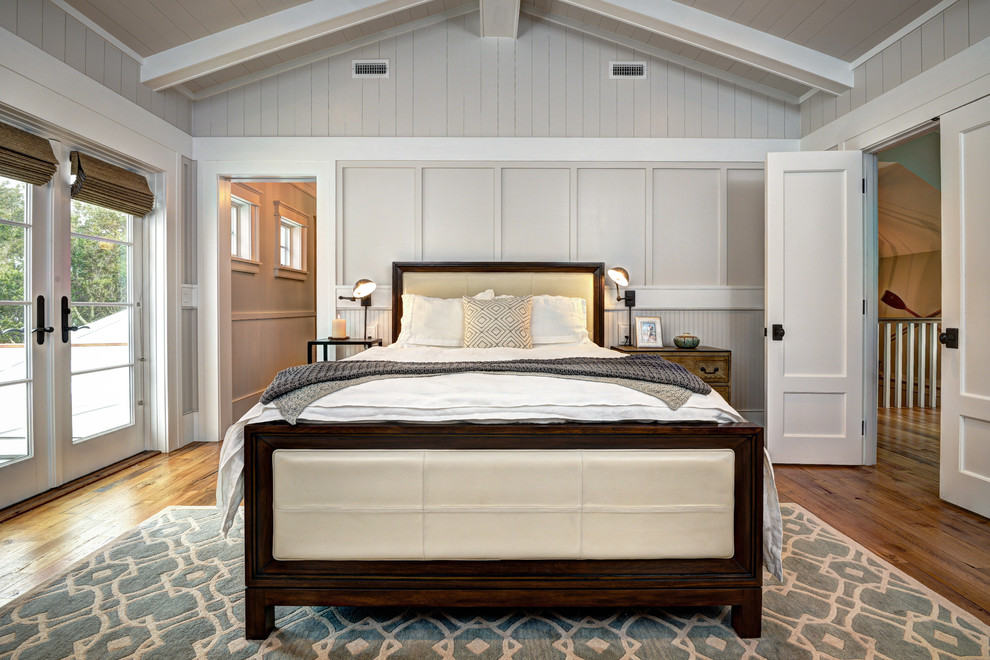Foto de dormitorio principal costero de tamaño medio con paredes grises y suelo de madera en tonos medios