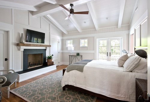Cozy bedroom with fireplace and bed, walls and ceiling in matching color scheme.