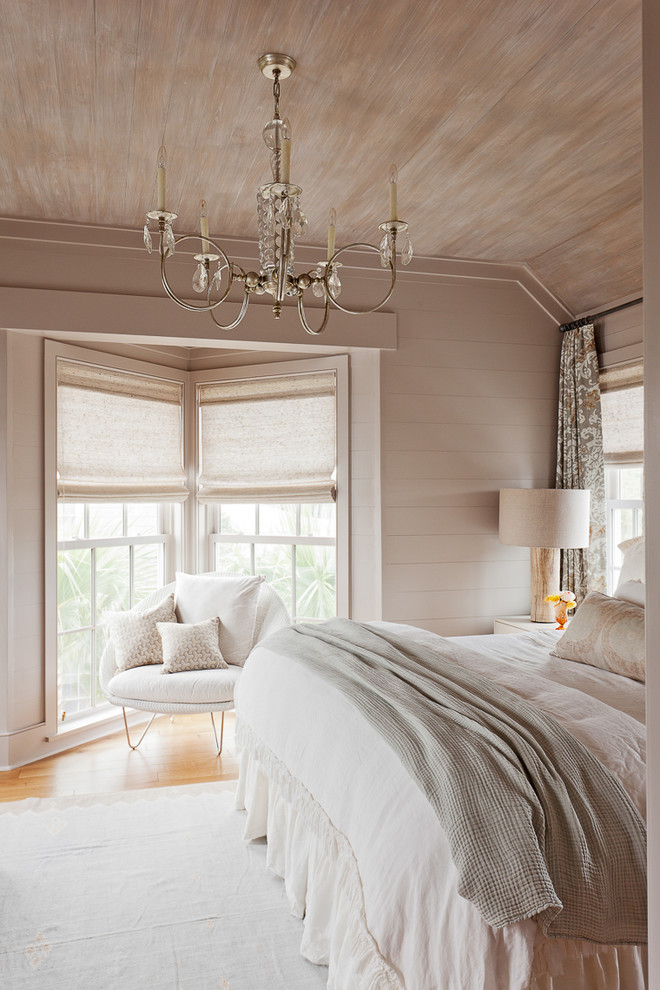 Immagine di una camera matrimoniale costiera con pareti beige e pavimento in legno massello medio