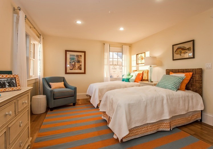 Exemple d'une chambre d'amis bord de mer de taille moyenne avec un mur beige, un sol en bois brun et aucune cheminée.