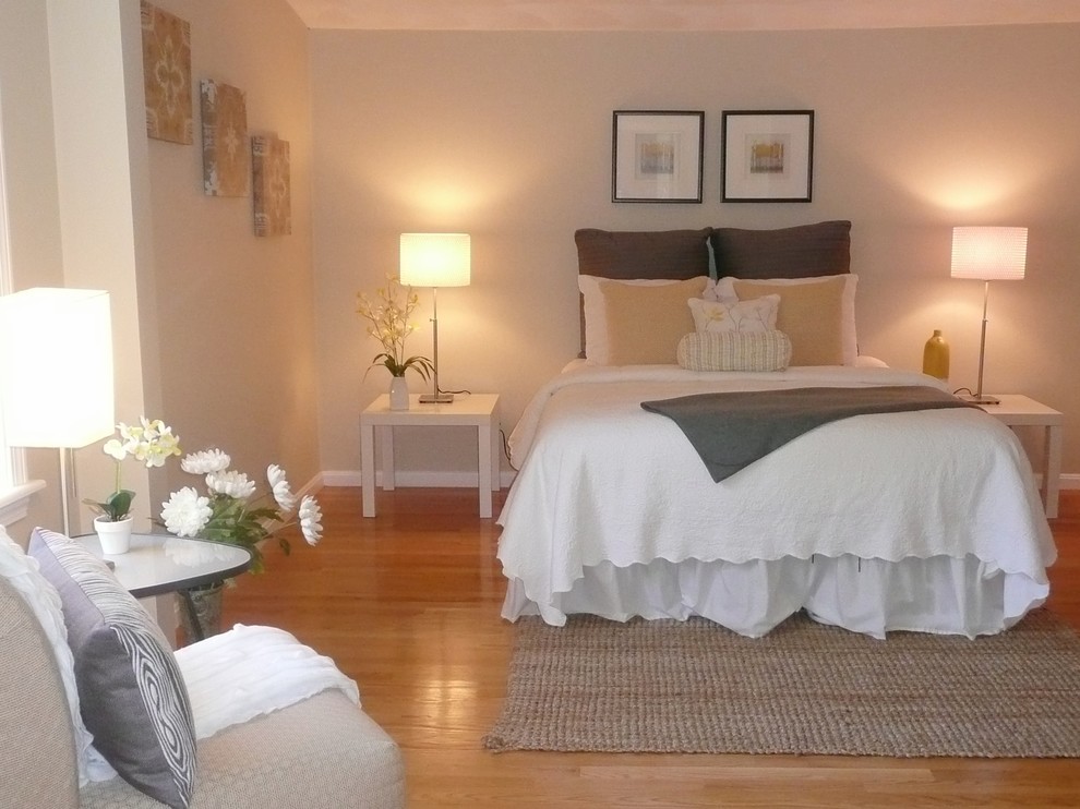 Ejemplo de dormitorio principal clásico renovado de tamaño medio sin chimenea con paredes beige y suelo de madera clara
