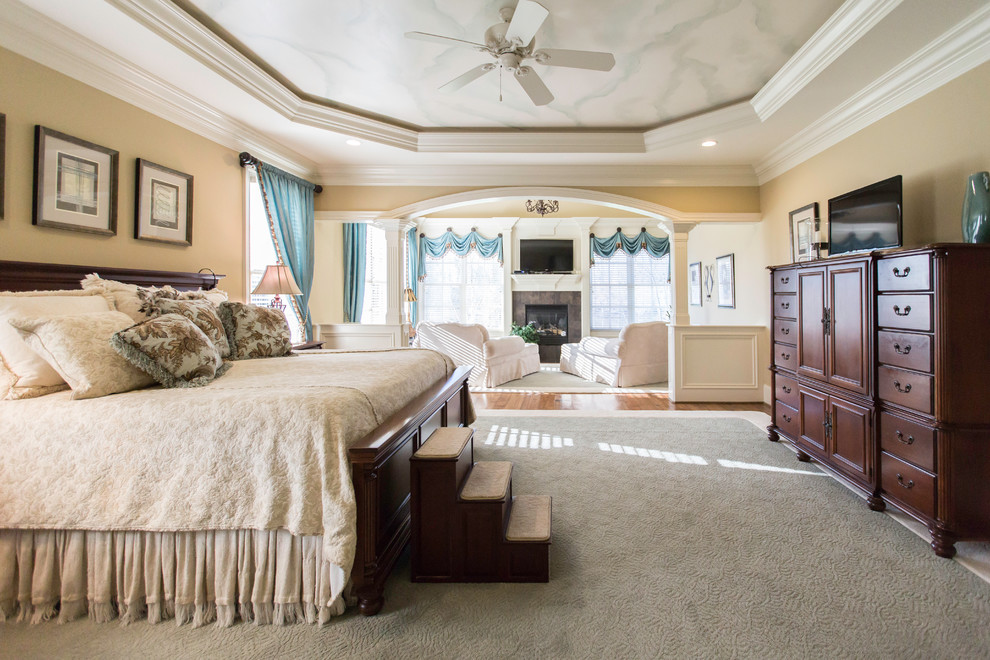Großes Klassisches Hauptschlafzimmer mit beiger Wandfarbe, Teppichboden, Kamin und gefliester Kaminumrandung in Raleigh