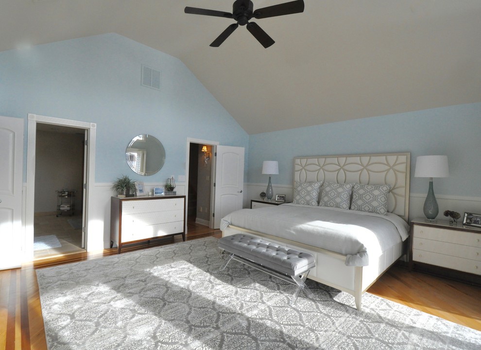 Imagen de dormitorio principal clásico renovado extra grande con paredes azules, suelo de madera en tonos medios, todas las chimeneas y marco de chimenea de madera