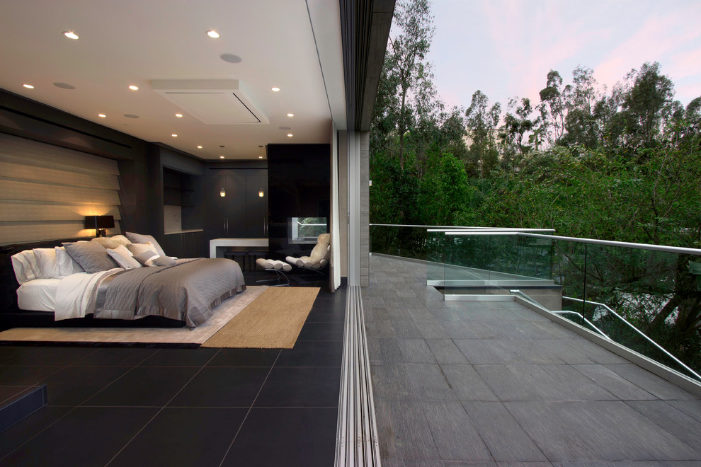 Mittelgroßes Modernes Gästezimmer mit grauer Wandfarbe, Marmorboden, Tunnelkamin, Kaminumrandung aus Stein und schwarzem Boden in Los Angeles