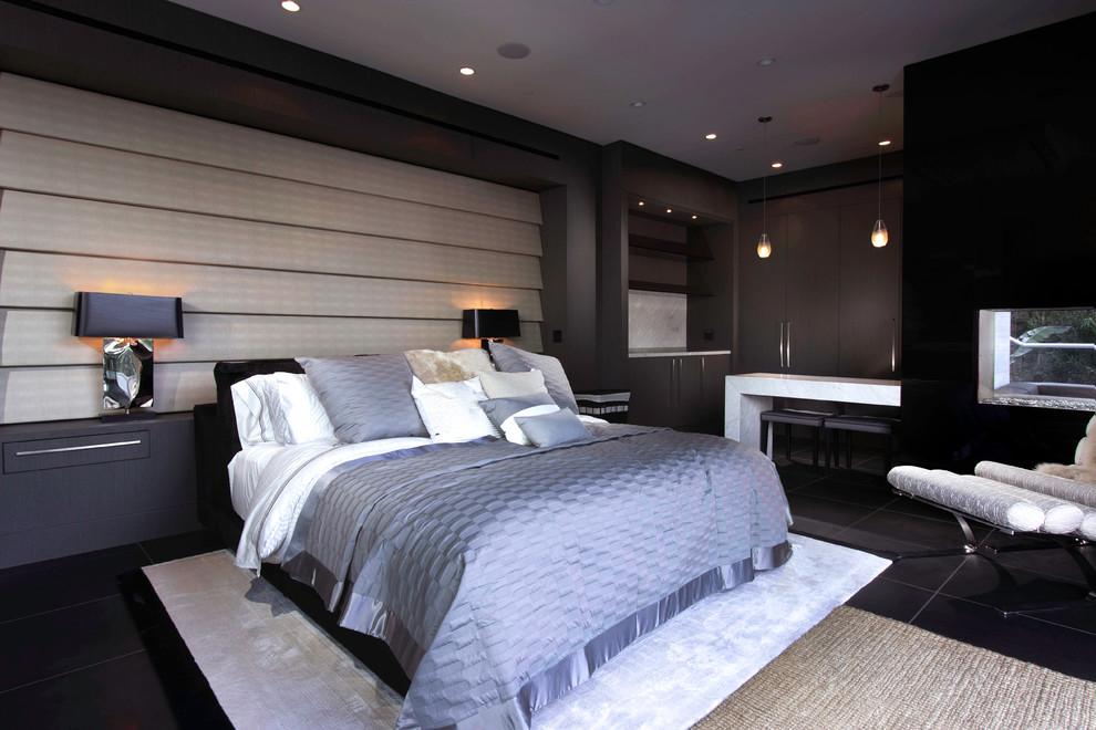 Modelo de habitación de invitados actual de tamaño medio con paredes grises, suelo de mármol, chimenea de doble cara, marco de chimenea de piedra y suelo negro