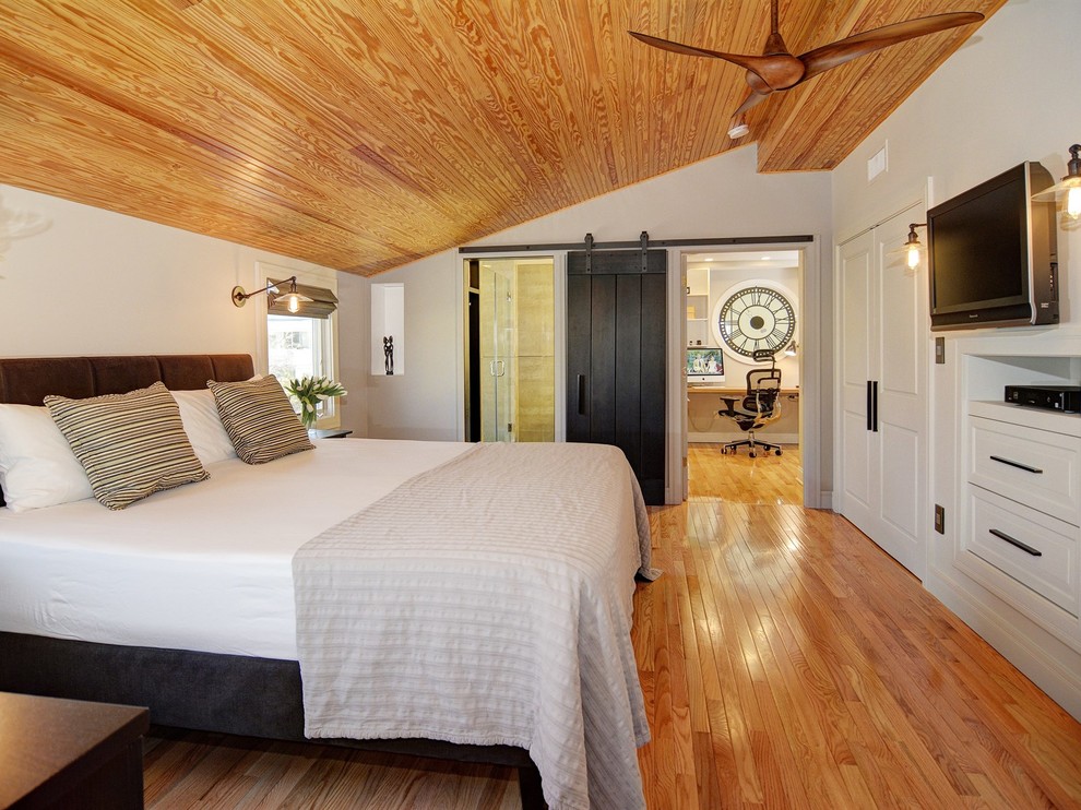 Aménagement d'une très grande chambre parentale classique avec un mur gris et un sol en bois brun.