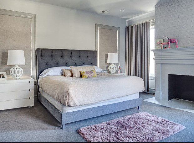 Cette photo montre une chambre tendance de taille moyenne avec un mur blanc, une cheminée standard, un manteau de cheminée en bois et un sol gris.