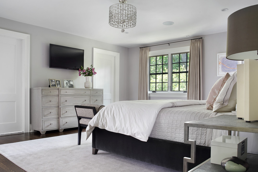 Стильный дизайн: гостевая спальня среднего размера, (комната для гостей) в стиле неоклассика (современная классика) с серыми стенами, темным паркетным полом, стандартным камином, фасадом камина из дерева и коричневым полом - последний тренд