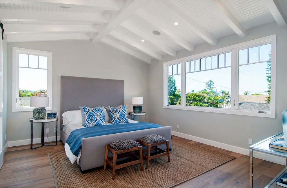 Medium sized beach style master bedroom in San Diego with grey walls and light hardwood flooring.