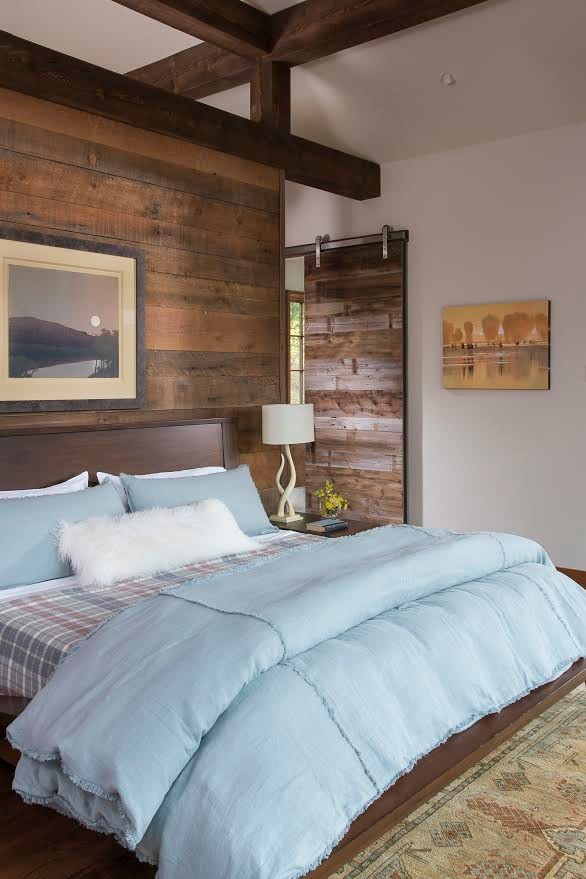 Imagen de dormitorio principal rústico grande sin chimenea con paredes blancas y suelo de madera oscura