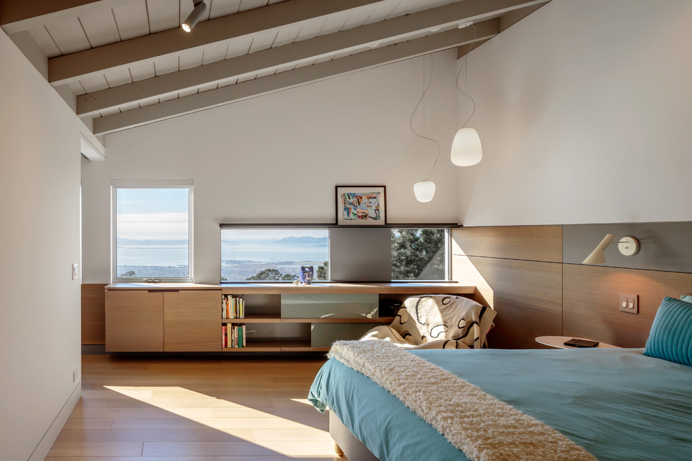 Imagen de dormitorio principal retro de tamaño medio sin chimenea con paredes blancas y suelo de madera clara